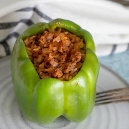 Stuffed pepper made in the crockpot shown from above on white plate.