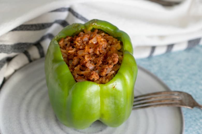 Stuffed pepper made in the crockpot shown from above on white plate.