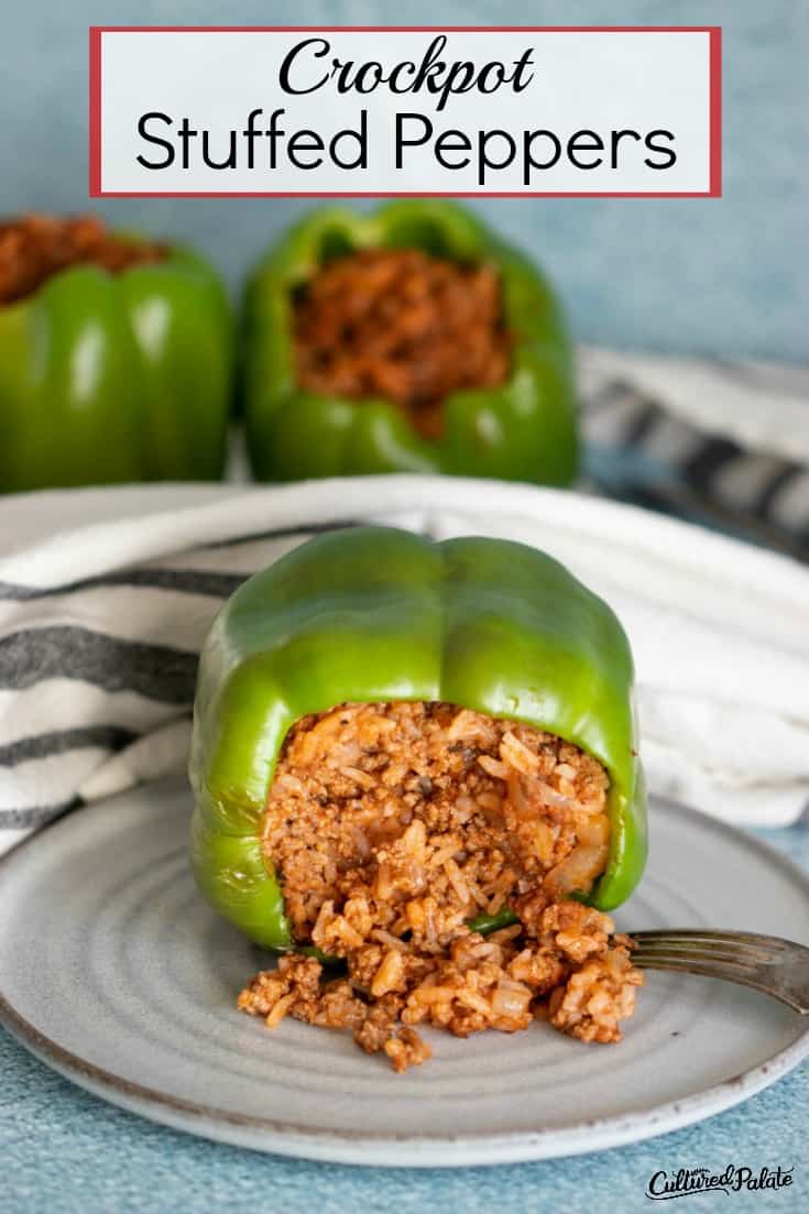 Stuffed pepper on its side with the filling spilling out onto a white plate.