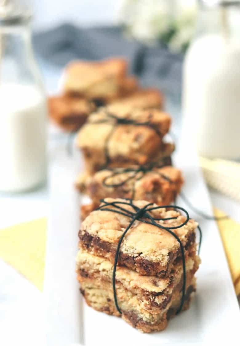 Keto Butterscotch Bars shown close up with milk in the background.