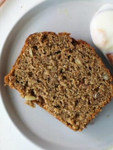 Grain-free Banana Bread with Almond Flour sliced on a plate with honey and yogurt.