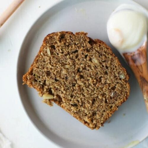 Grain-free Banana Bread with Almond Flour sliced on a plate with honey and yogurt.