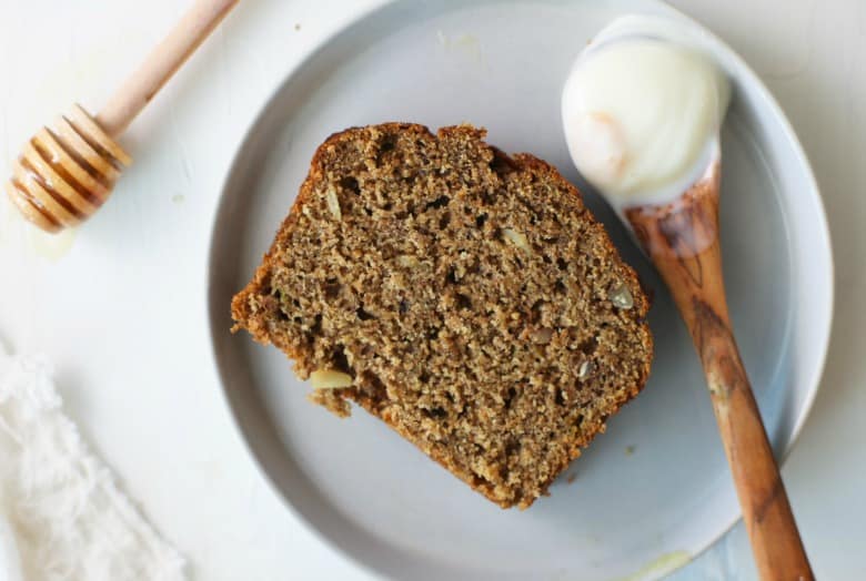 Grain-free Banana Bread with Almond Flour sliced on a plate with honey and yogurt.