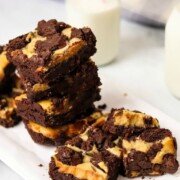 Marbled Peanut Butter Brownies stacked on plate with milk in the background