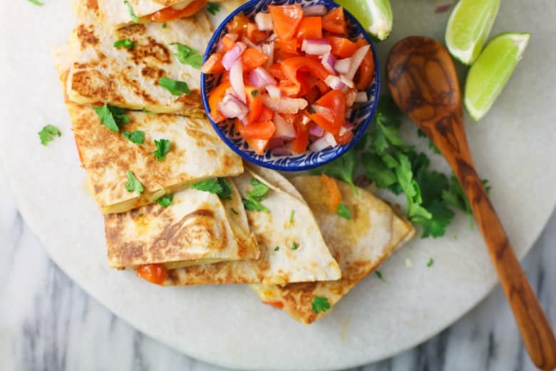 Mozzarella Quesadillas shown from overhead on white platter and salsa in the center.