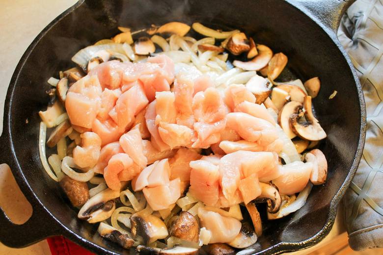 chicken cooked with mushrooms and onions in skillet